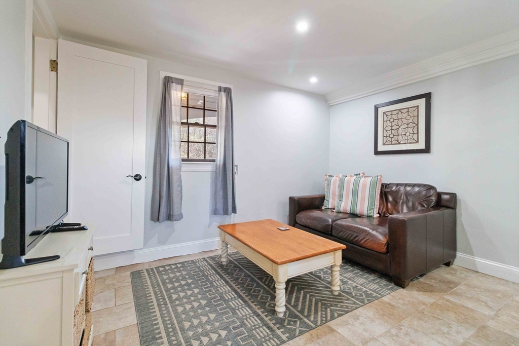21 A Stowe Road, Unit A Southborough, MA 01772 - Photo 9 of 24 a living room with a couch and a flat screen tv