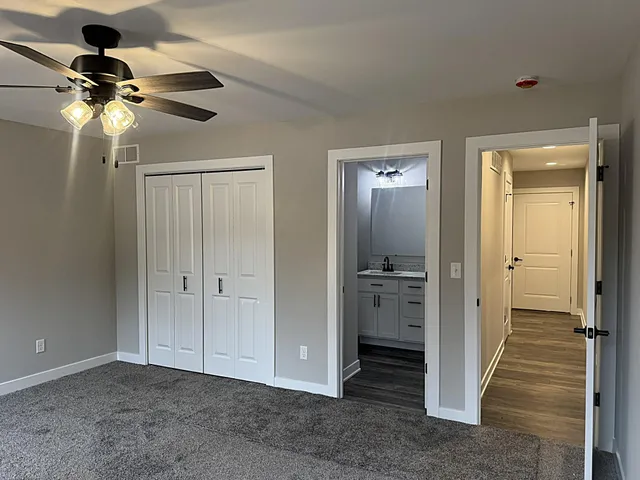 an empty room with windows and fan