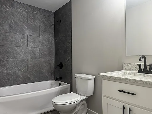 a bathroom with a toilet and a bath tub