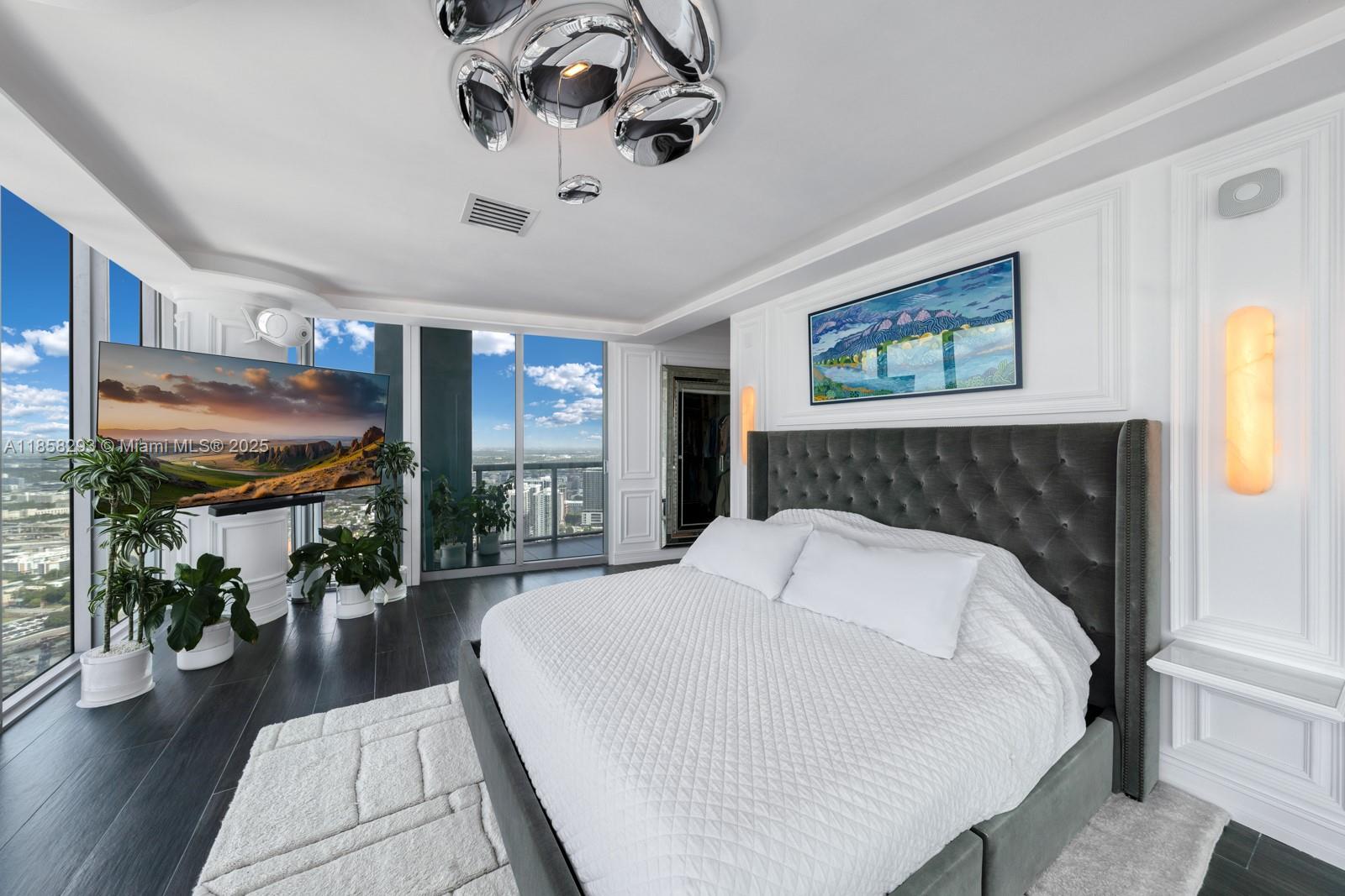 888 Biscayne Boulevard, Unit 5701 Miami, FL 33132 - Photo 16 of 35 a bed room with a bed and a chandelier