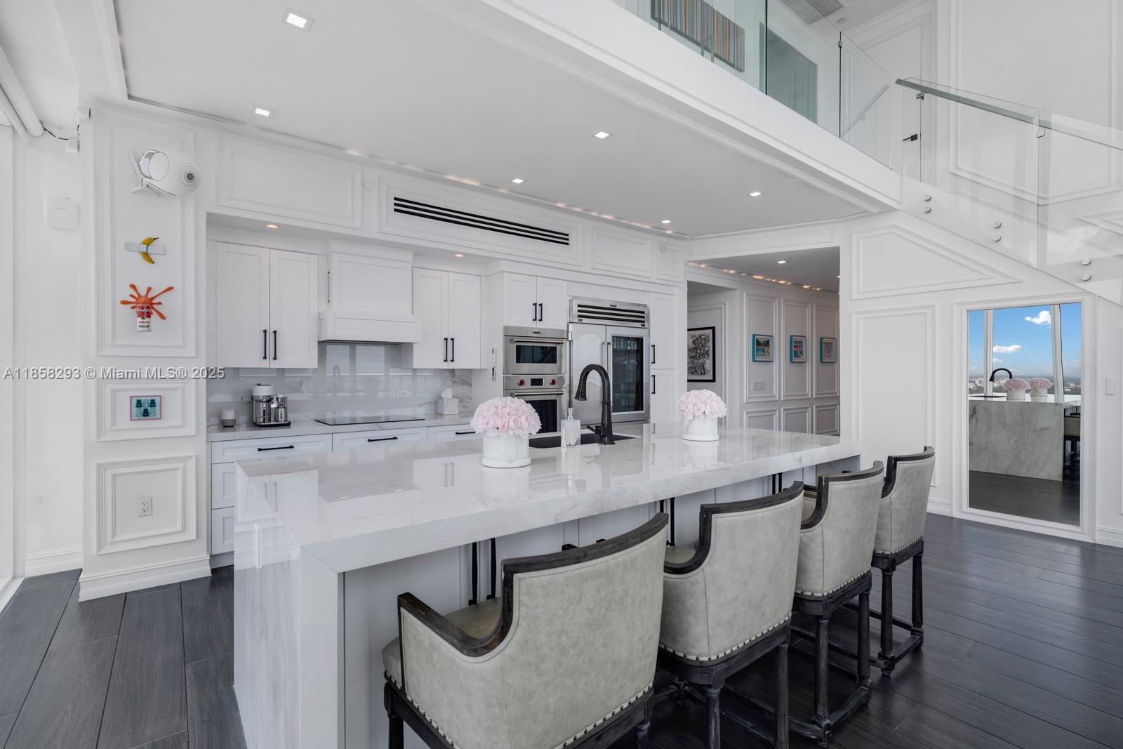 888 Biscayne Boulevard, Unit 5701 Miami, FL 33132 - Photo 9 of 35 a kitchen with stainless steel appliances granite countertop a table chairs sink and cabinets