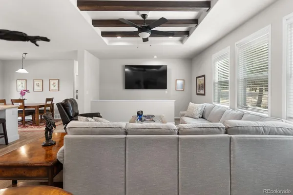 a living room with furniture a flat screen tv and a window