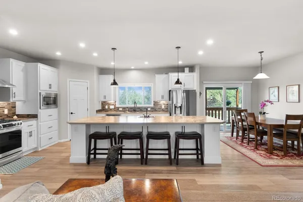 a large kitchen with kitchen island a dining table and chairs