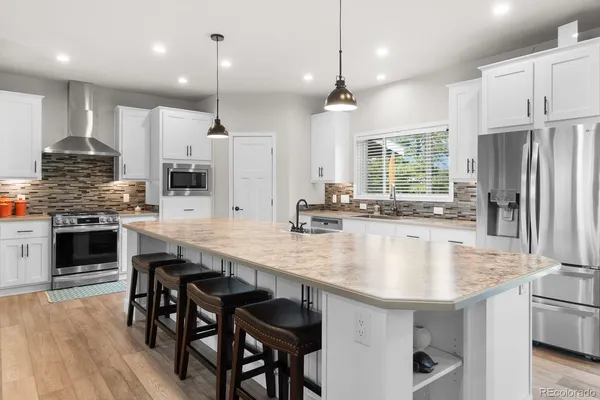 a large kitchen with kitchen island a table and chairs