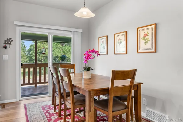 a dining room with furniture a large window and wooden floor