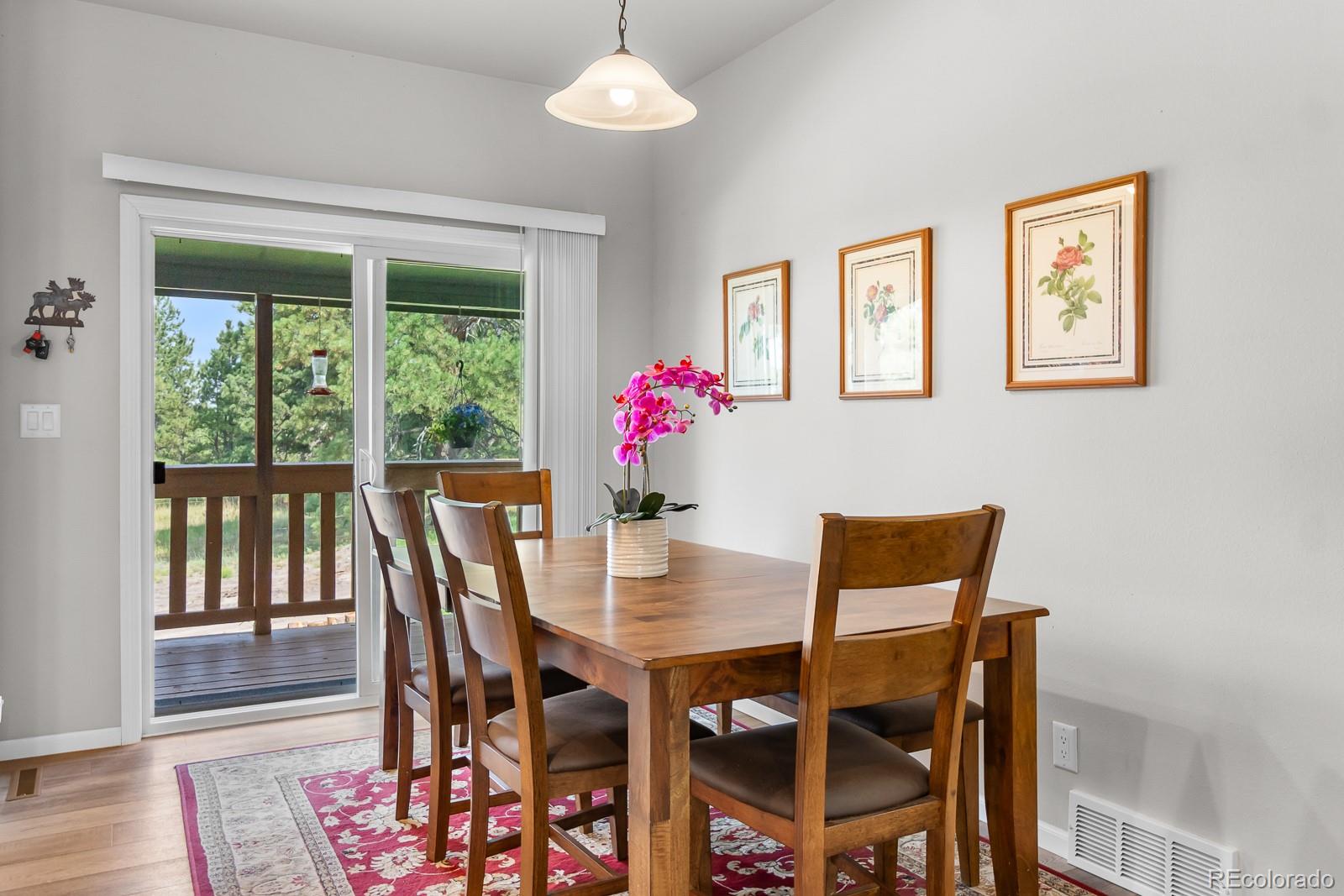 11374 Ridgewood Way Kiowa, CO 80117 - Photo 18 of 49 a dining room with furniture a large window and wooden floor