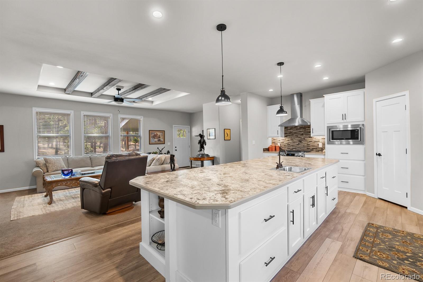 11374 Ridgewood Way Kiowa, CO 80117 - Photo 19 of 49 a large kitchen with kitchen island a large counter top space a sink stainless steel appliances and cabinets