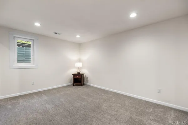 an empty room with chandelier and window