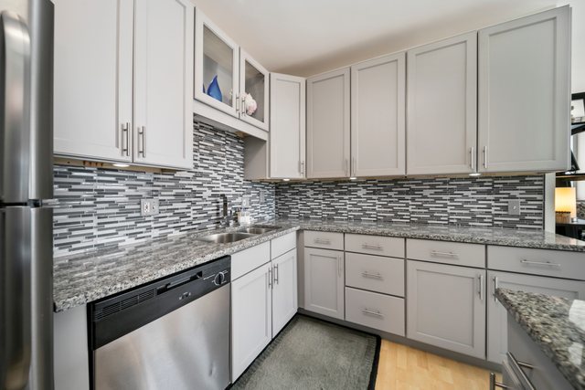 600 North Dearborn Street, Unit 1102 Chicago, IL 60654 - Photo 11 of 26 a kitchen with stainless steel appliances granite countertop a sink and cabinets