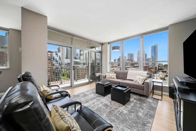 600 North Dearborn Street, Unit 1102 Chicago, IL 60654 - Photo 2 of 26 a living room with furniture large windows and a flat screen tv