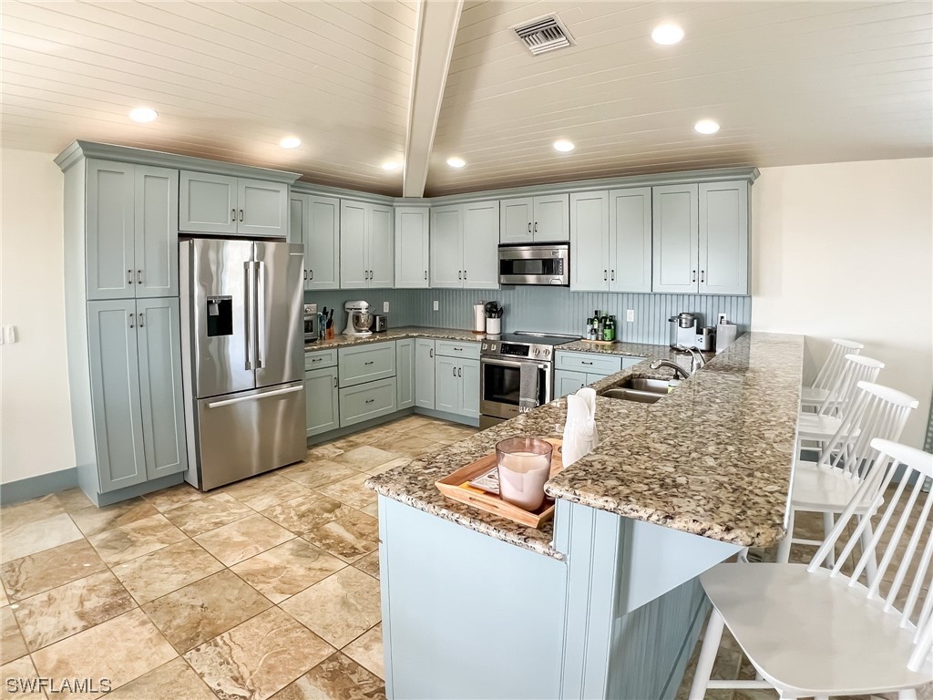 4480 Panama Shell Drive Upper Captiva, FL 33924 - Photo 24 of 50 a kitchen with granite countertop a refrigerator and a stove top oven