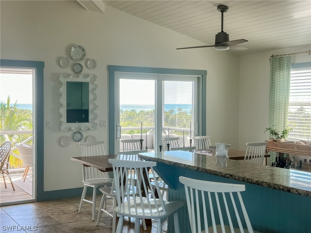 4480 Panama Shell Drive Upper Captiva, FL 33924 - Photo 32 of 50 a dining room with wooden floor a chandelier a wooden table and chairs