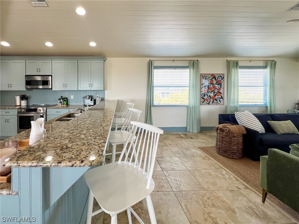 4480 Panama Shell Drive Upper Captiva, FL 33924 - Photo 34 of 50 a view of kitchen with granite countertop stove top oven microwave and cabinets
