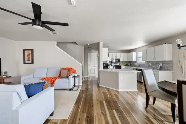 a living room with furniture and a view of kitchen