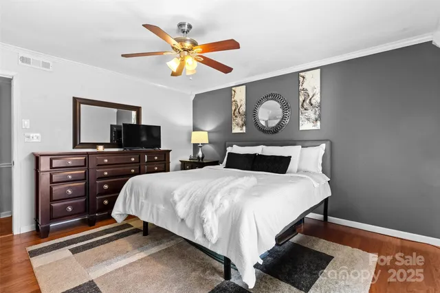 a bedroom with a bed and a tv on the wall