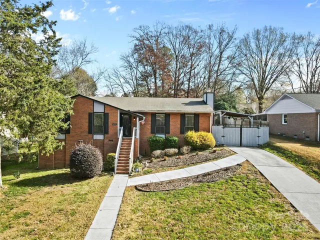 a front view of a house with a yard and potted plants