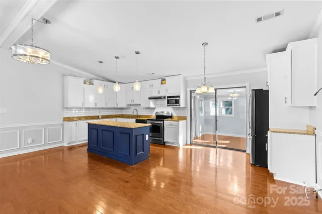 a kitchen with stainless steel appliances granite countertop a refrigerator a sink and a stove