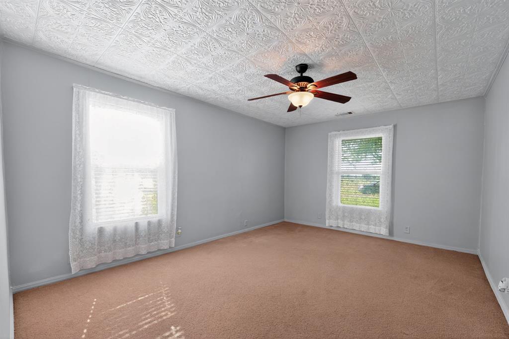5485 Highway 7 Marlin, TX 76661 - Photo 19 of 36 Spare room with carpet flooring, a ceiling fan, and an ornate ceiling
