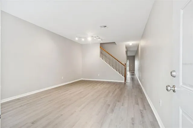 an empty room with wooden floor and window