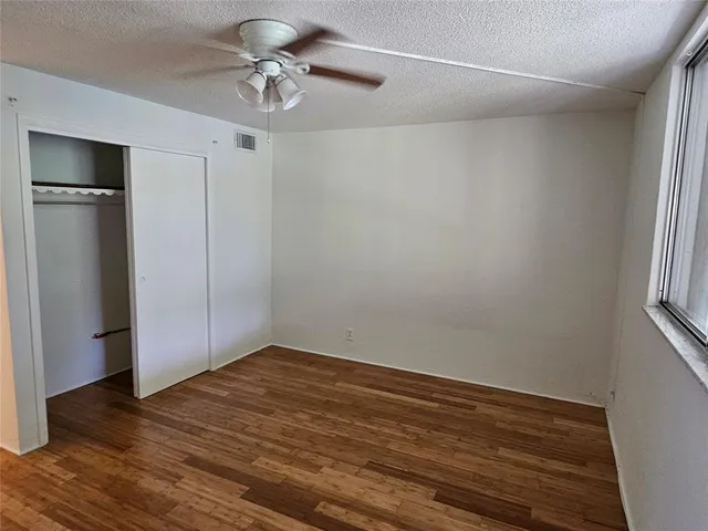 a view of wooden floor and chandelier fan in a room