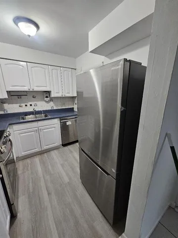a kitchen with stainless steel appliances a refrigerator sink and microwave
