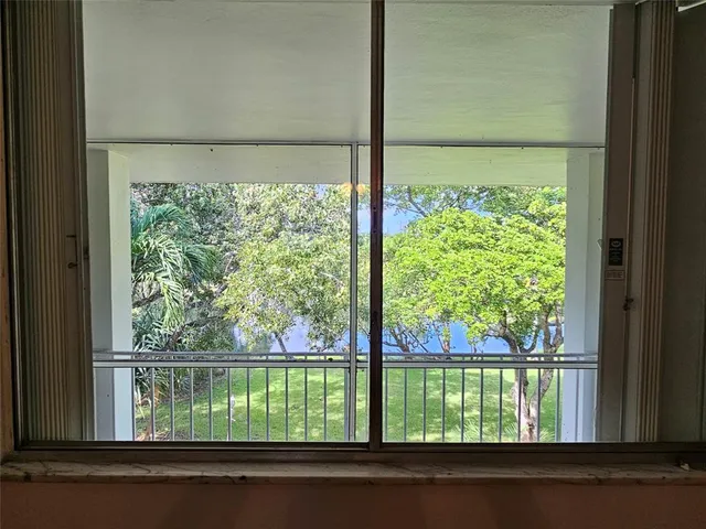 a view of a house with a big yard and large trees