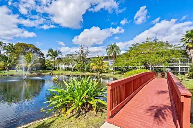 a view of a lake with a yard and a large tree