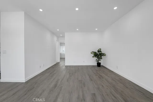 a view of a big room with wooden floor and windows
