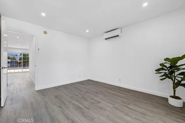 a room with wooden floor and a potted plant
