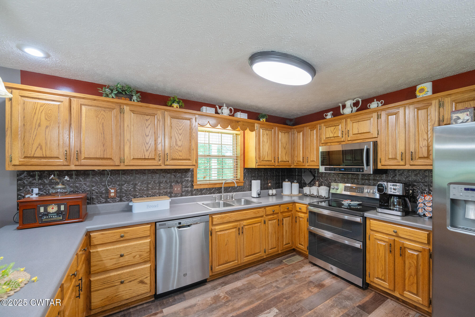 1401 Camper Road Decaturville, TN 38329 - Photo 18 of 40 a kitchen with stainless steel appliances granite countertop a sink a stove a refrigerator cabinets and a window