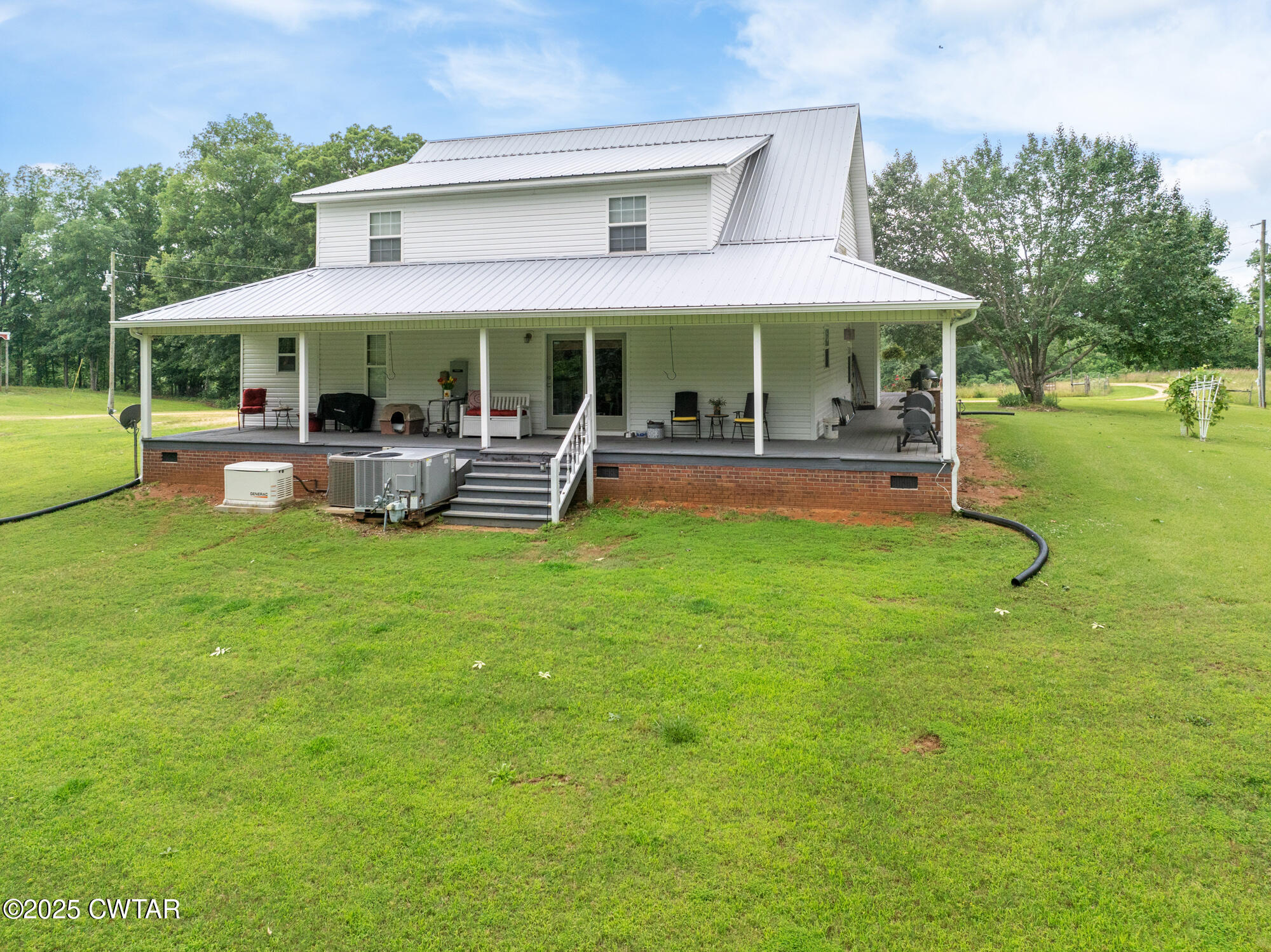 1401 Camper Road Decaturville, TN 38329 - Photo 6 of 40 a front view of a house with a yard table and chairs