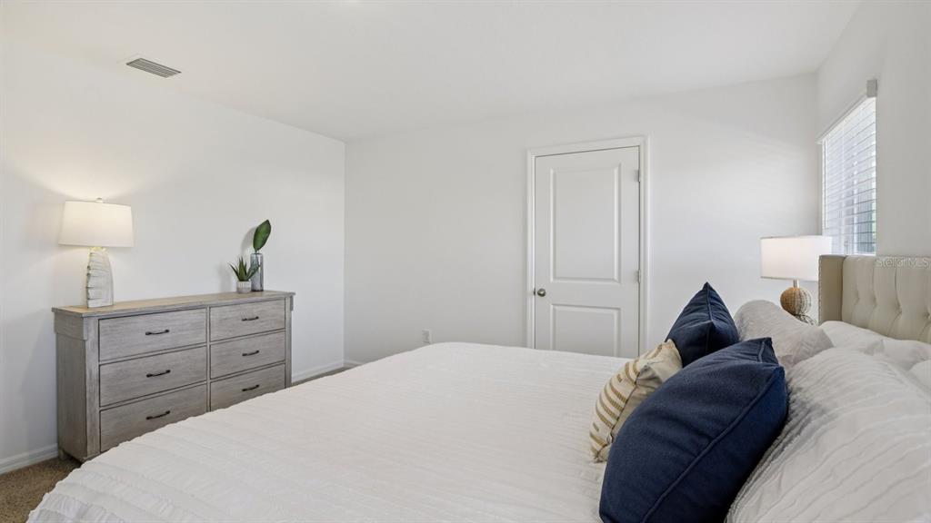 1060 Spotted Egret Loop Ruskin, FL 33570 - Photo 17 of 26 a bedroom with a bed and a dresser
