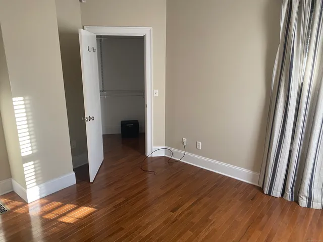 an empty room with wooden floor and a window