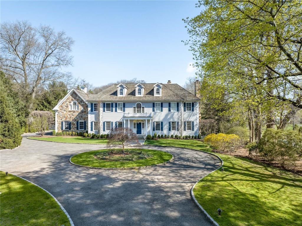 23 Pleasant Ridge Road Harrison, NY 10528 - Photo 1 of 1 a front view of a house with a garden and trees