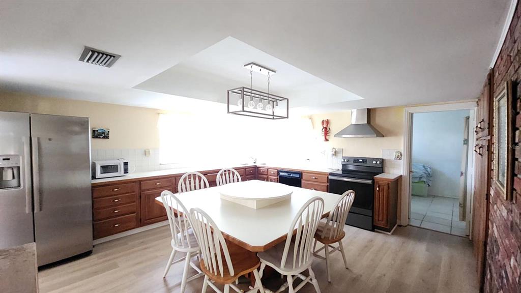 2405 Neptune Road Kissimmee, FL 34744 - Photo 17 of 17 a kitchen with stainless steel appliances granite countertop a dining table and chairs