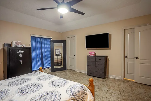 a bedroom with a bed and a flat tv screen on dresser