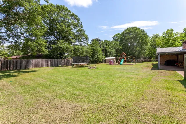 a view of a swimming pool with a bench and trees
