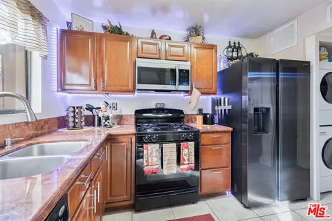 a kitchen with stainless steel appliances granite countertop a stove refrigerator and microwave