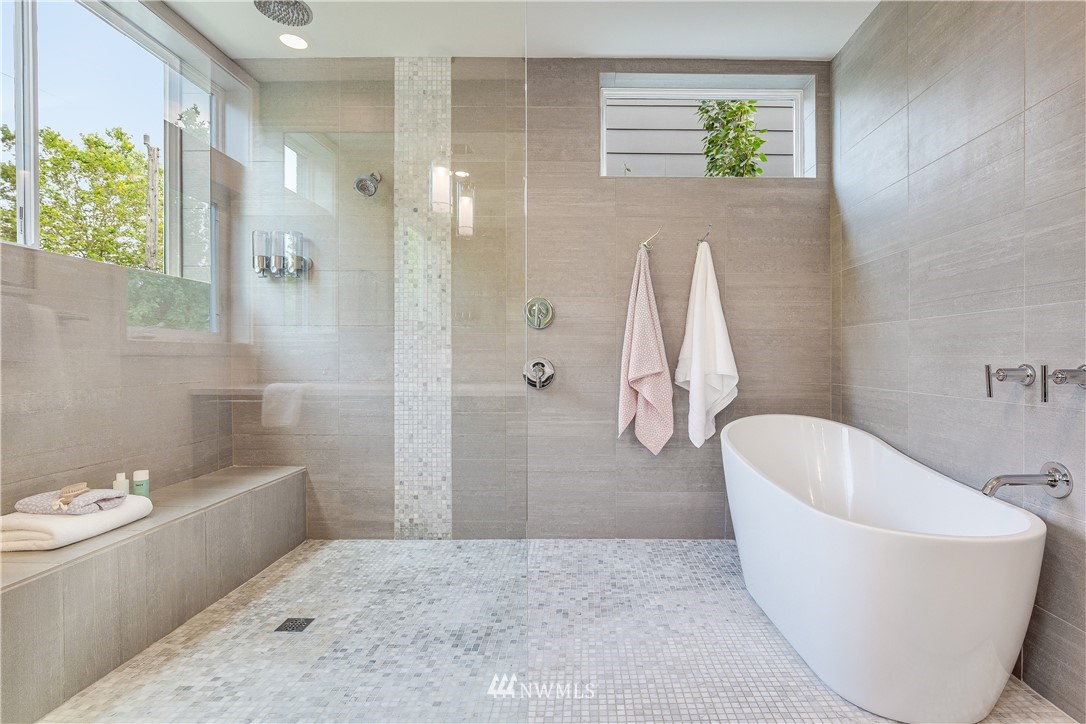 3217 East Spring Street Seattle, WA 98122 - Photo 16 of 33 a bathroom with a white tub a window and glass door shower