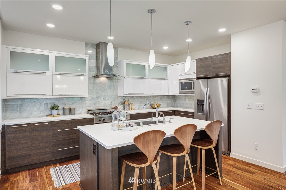 3217 East Spring Street Seattle, WA 98122 - Photo 9 of 33 a kitchen with a sink a stove a refrigerator and cabinets