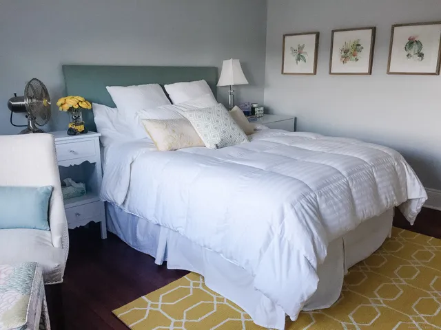 a bedroom with a bed and window with lamp