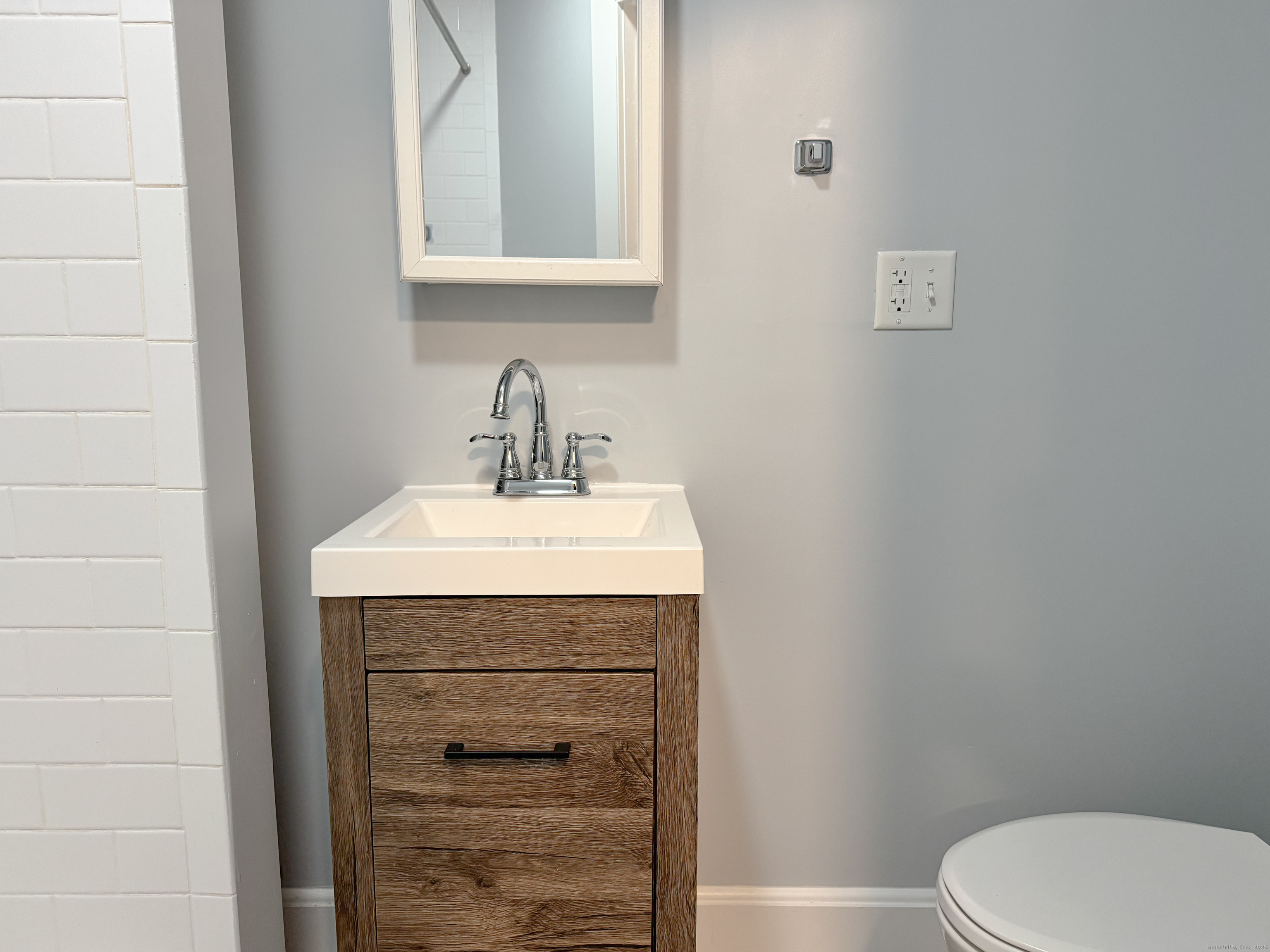 46 Riverside Drive Fairfield, CT 06824 - Photo 17 of 20 a bathroom with a sink a toilet and mirror
