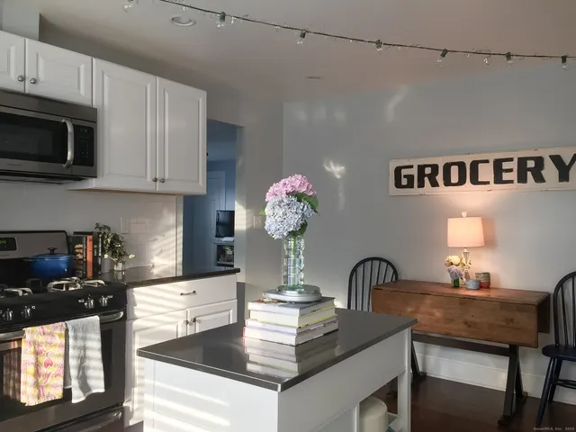 a kitchen with granite countertop a stove and white cabinets