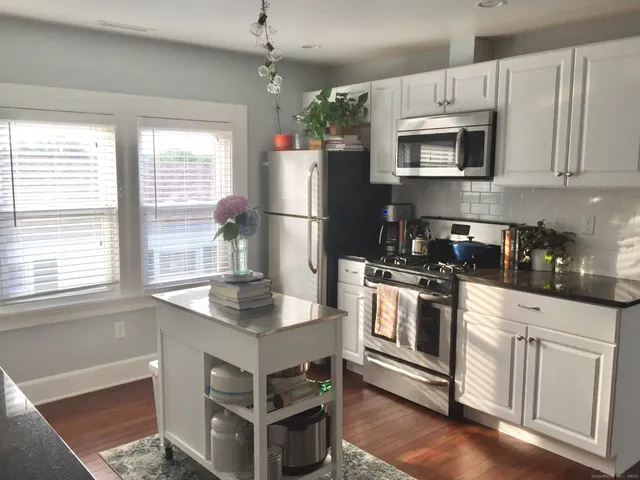 a kitchen with white cabinets and appliances