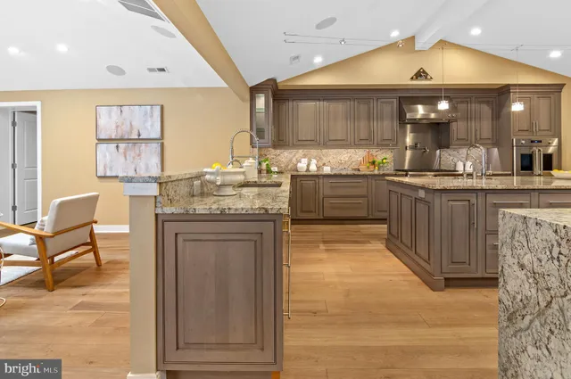 a kitchen with stainless steel appliances granite countertop a stove and cabinets
