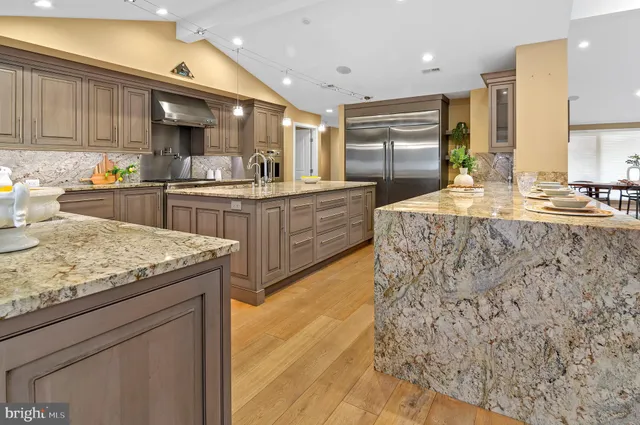 a kitchen with stainless steel appliances granite countertop a granite counter tops and a view of living room