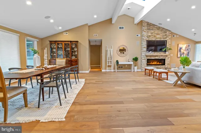 a living room with stainless steel appliances kitchen island granite countertop a table chairs and a barbeque view of living room