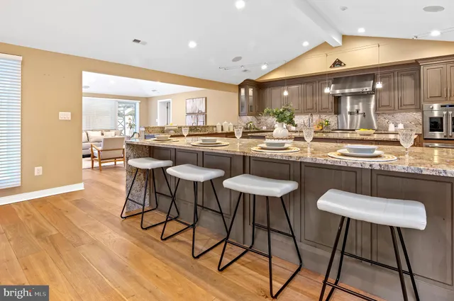 a kitchen with a dining table chairs and sink