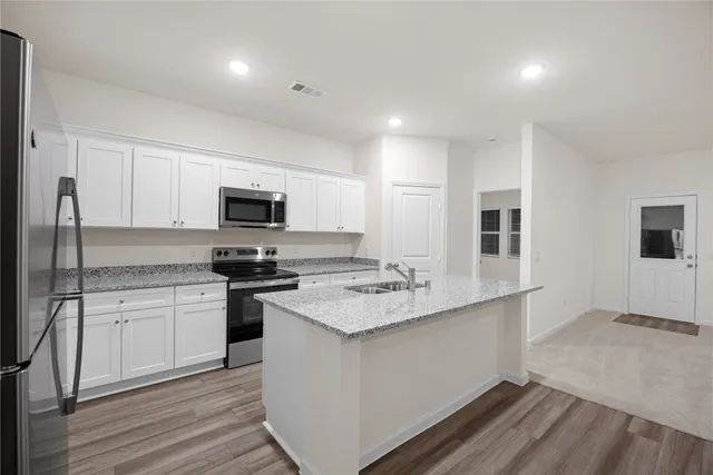 a kitchen with stainless steel appliances granite countertop a sink stove and microwave