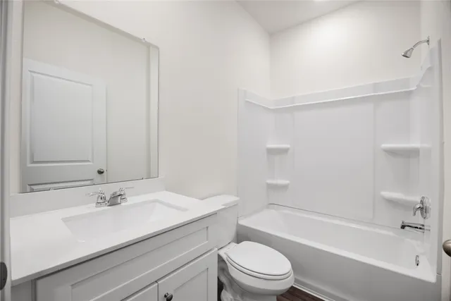 a bathroom with a granite countertop sink a toilet and shower